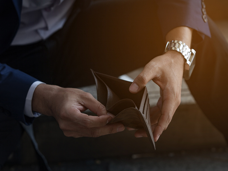 man sitting and looking at open empty wallet gahanna oh
